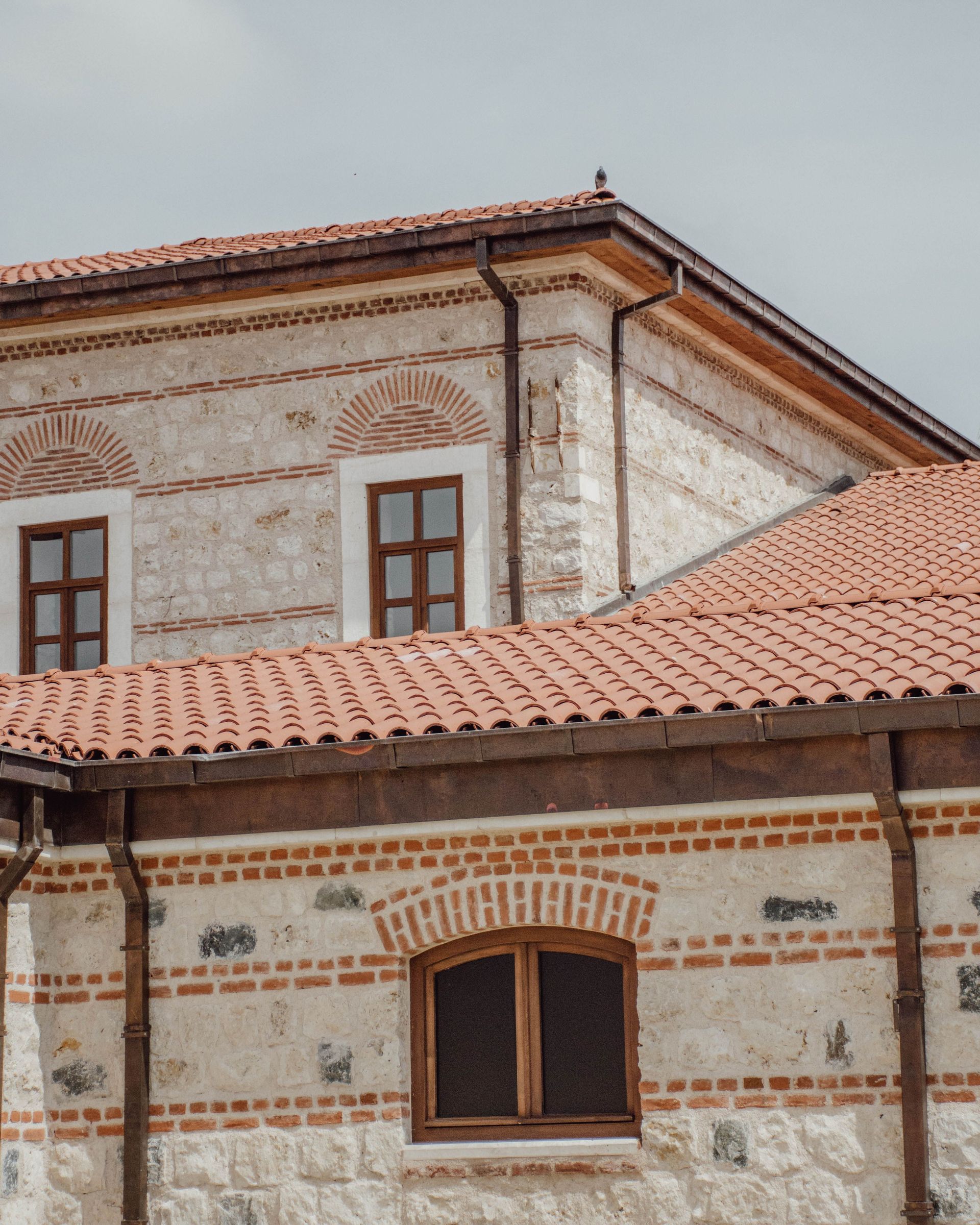Charming historic building with terracotta roof tiles and rustic windows, showcasing classic architecture.