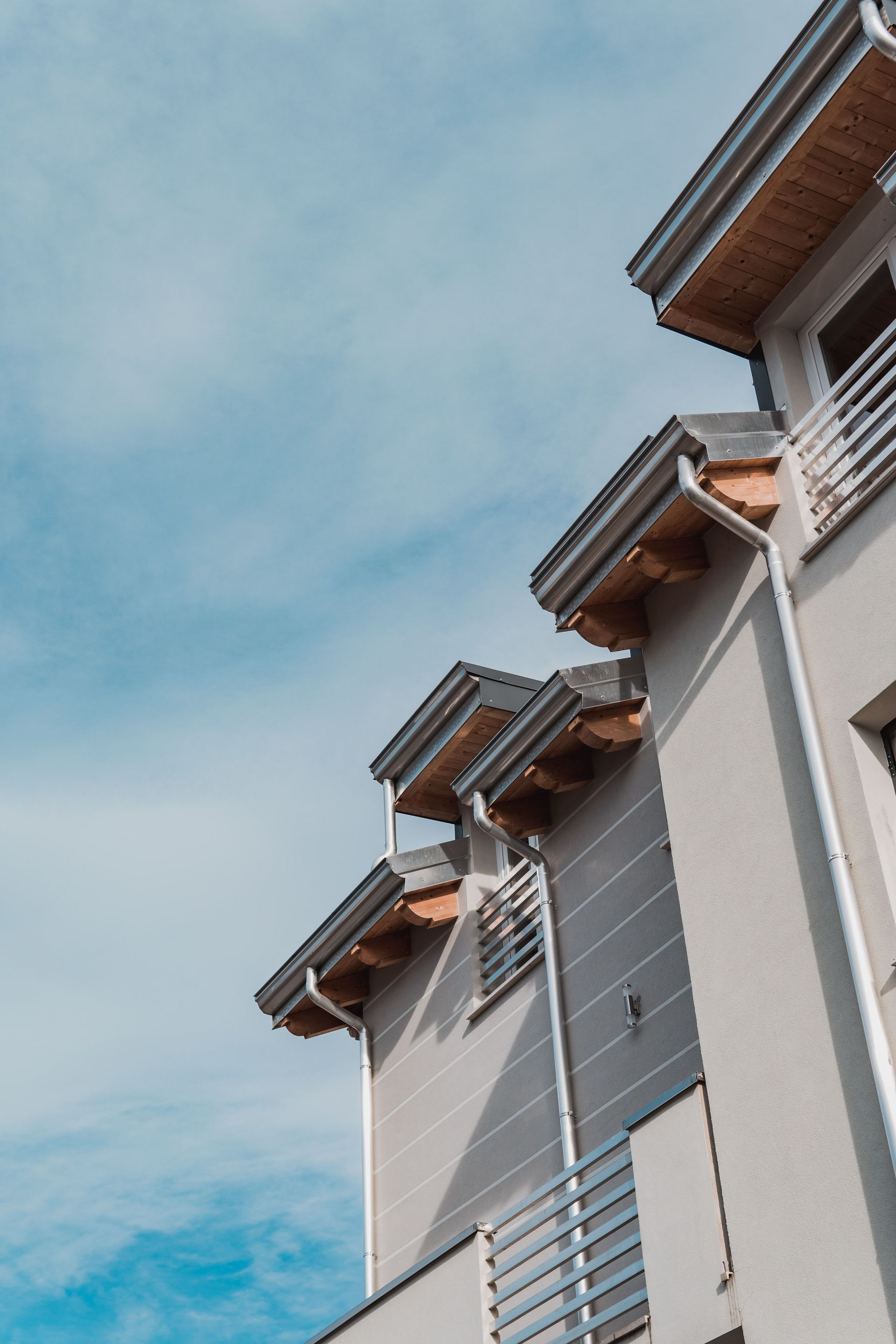 Angled view of a modern building against a bright blue sky, showcasing clean lines and contemporary design.