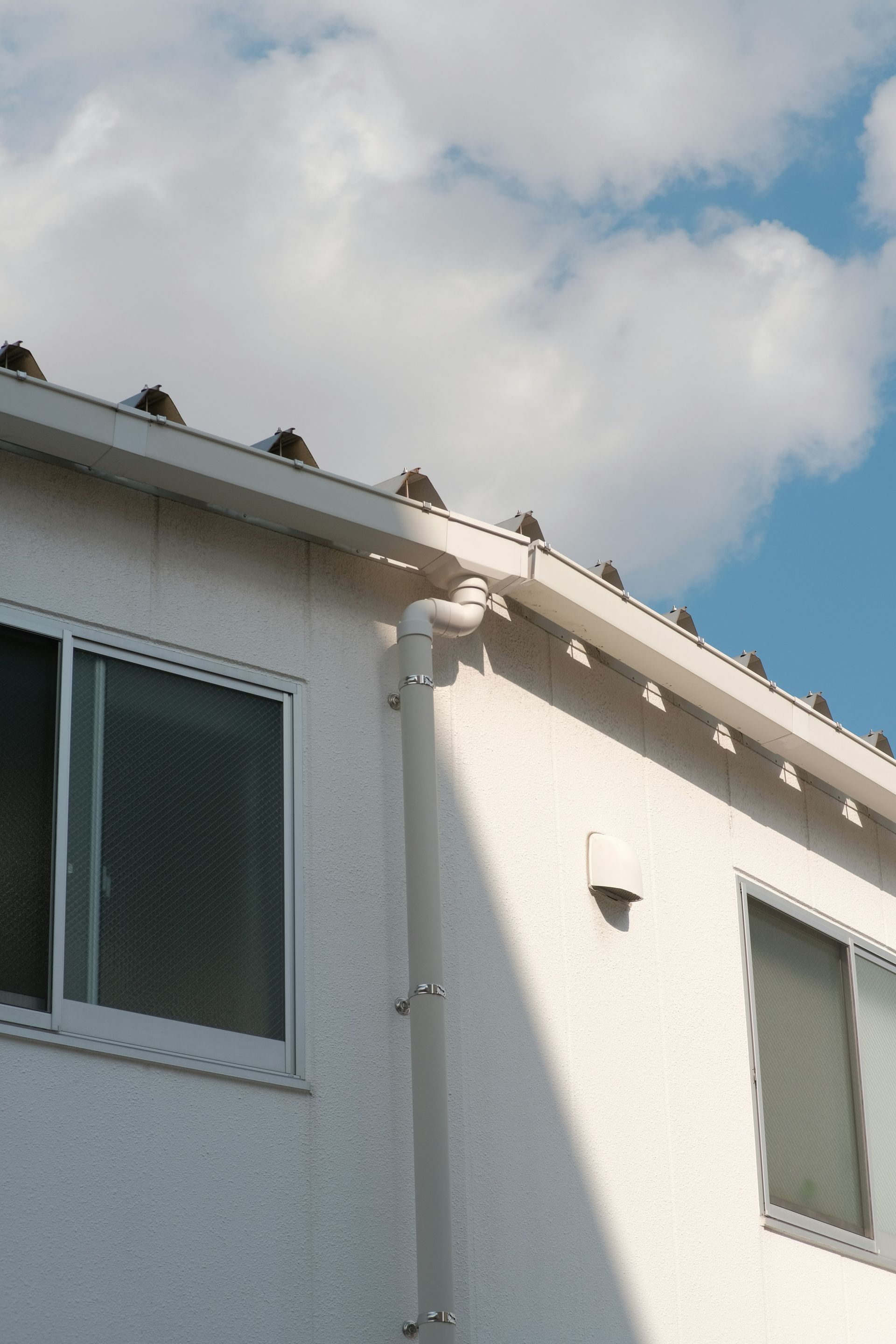 a white building with birds perched on the roof